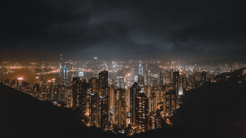 Illuminated cityscape against sky at night