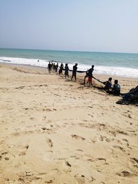 People on beach against sky