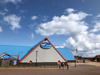 People playing basketball court against sky