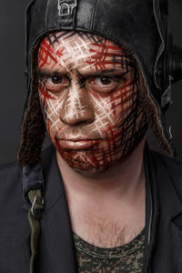 Close-up of man with face paint against black background