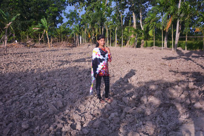 Full length portrait of girl standing on mud