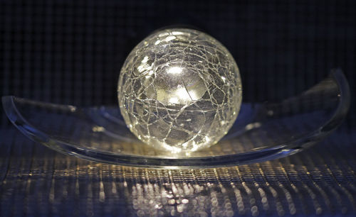 Close-up of crystal ball on glass table