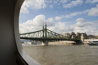 Bridge over river against cloudy sky