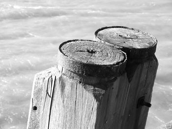 Close-up of old wooden post at beach against sky