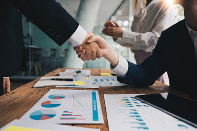 Midsection of business people shaking hands
