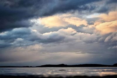 Scenic view of sea against storm clouds