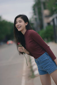 Portrait of smiling young woman standing outdoors