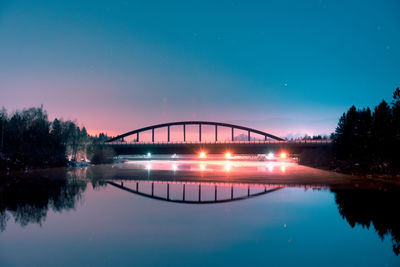 Bridge over river against sky at night