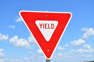 Low angle view of road sign against sky