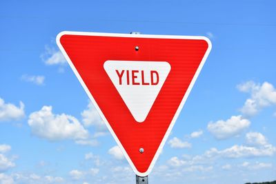 Low angle view of road sign against sky