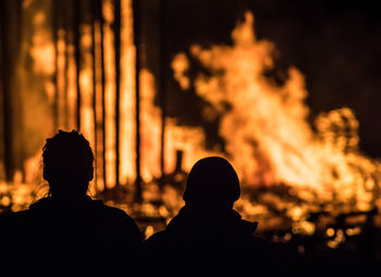 Close-up of silhouette people against tree at night