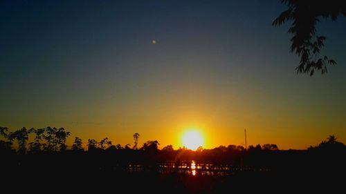 Silhouette trees against sky during sunset