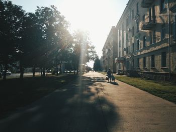 Man walking on road along buildings