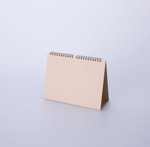 High angle view of blank brown desk calendar on white background