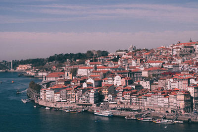 Aerial view of town by sea against sky