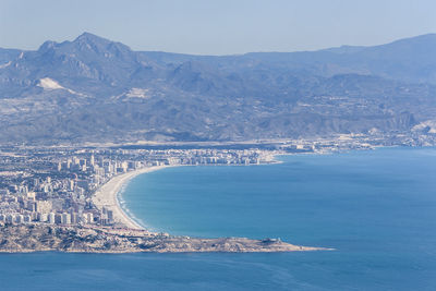 Aerial view of city by sea against sky