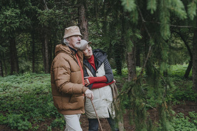 Thoughtful couple standing in forest