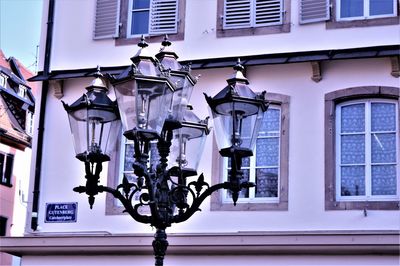 Low angle view of electric lamp hanging on window