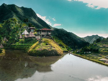 Scenic view of lake and houses against sky