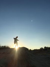 Silhouette man standing against bright sun