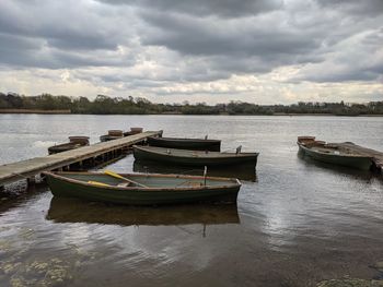 Boat moored in lake against sky