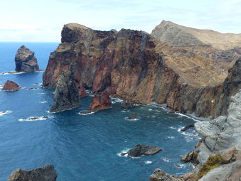 Scenic view of rocks in sea against sky