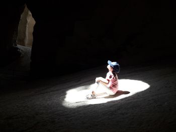 High angle view of sunlight falling on boy sitting in caves