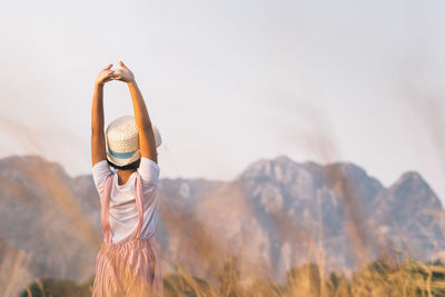 Rear view of woman standing in mountains