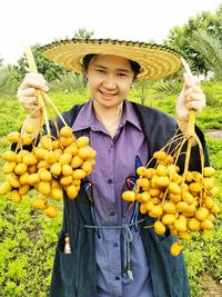 Portrait of smiling woman holding fruit