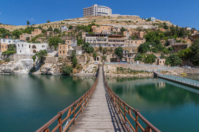 Footbridge over river with buildings in background