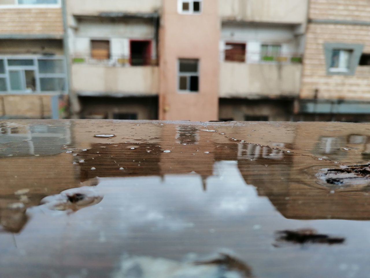 REFLECTION OF BUILDINGS IN PUDDLE