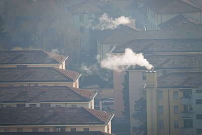 Smoke emitting from chimney outside house against sky