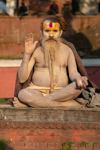 Man sitting on sculpture