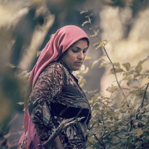 Woman looking away while standing on land