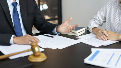 Midsection of business people working on table