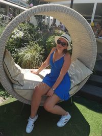 Young woman wearing sunglasses sitting outdoors