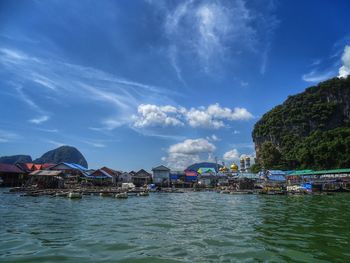 Scenic view of sea by houses against sky