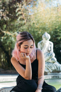 Full length of a young woman sitting outdoors