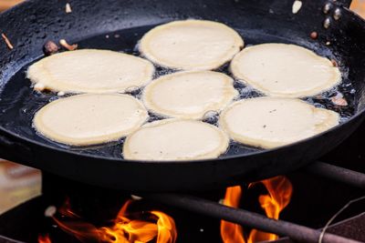 Cooking blini, blin or blynai, pancakes traditional sweet food, preparing outdoor on an open fire