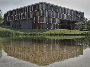 Reflection of building in lake against sky