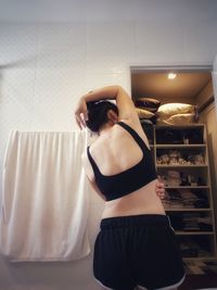 Rear view of woman standing against at home
