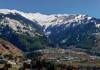 Aerial view of townscape and mountains against sky