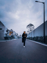 Man standing on street against sky