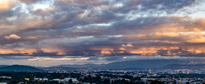 Aerial view of illuminated city against sky at sunset