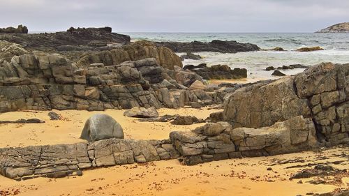 Rocks on beach against sky