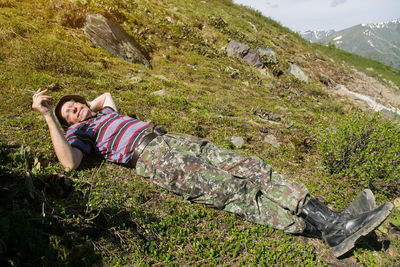 Full length of man smoking while lying on grass