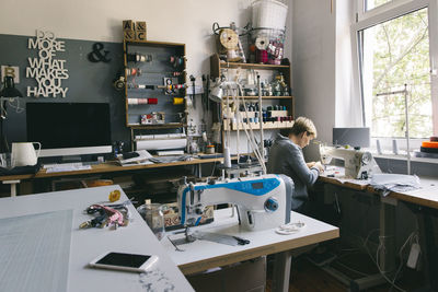 Woman using sewing machine in studio