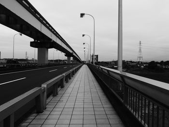 Bridge over road in city against sky