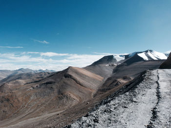 Scenic view of mountains against blue sky in winter