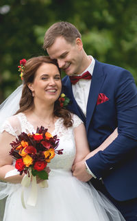 Smiling young couple romancing while standing at park